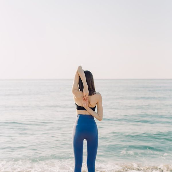 Person stretching gently outdoors during a calm morning.